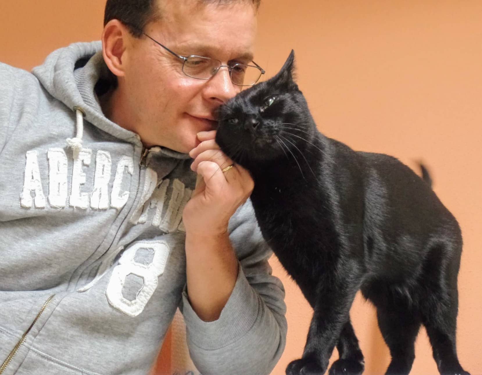 Manfred Gröh schmust mit einem schwarzen Kater